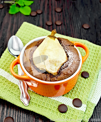 Image of Cake chocolate with pear in red bowl on green napkin