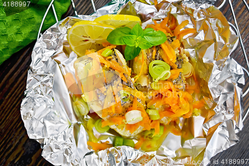 Image of Pike with carrots and basil in foil on board top