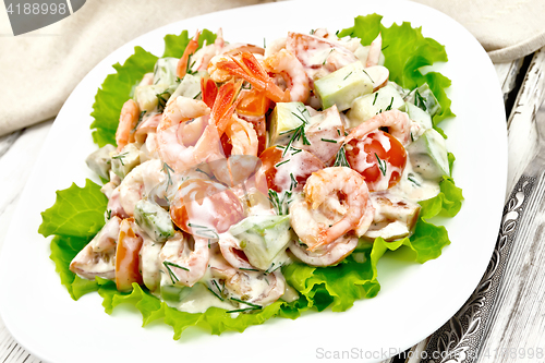 Image of Salad with shrimp and avocado in plate on board