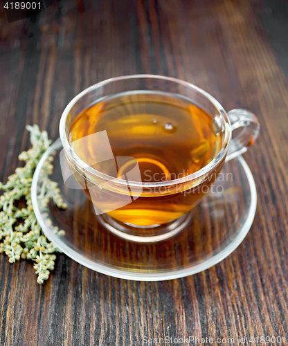 Image of Tea with wormwood in glass cup on board