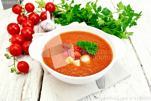 Image of Soup tomato in white bowl with vegetables on napkin