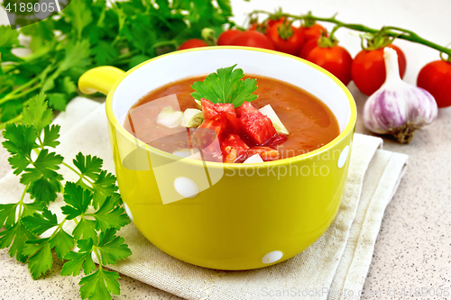 Image of Soup tomato in yellow bowl on towel