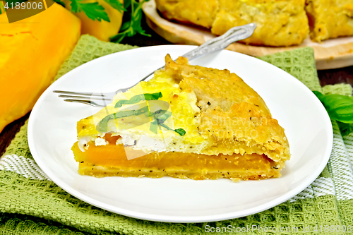 Image of Pie of pumpkin and cheese in white plate on board