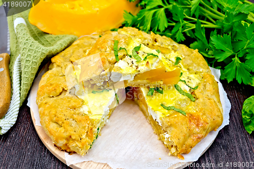 Image of Pie of pumpkin and cheese with parsley on board