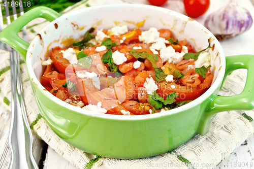 Image of Shrimp and tomato with feta in green pan on light board