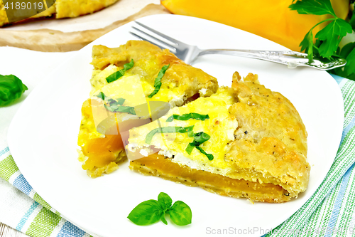 Image of Pie of pumpkin and cheese in plate on light board