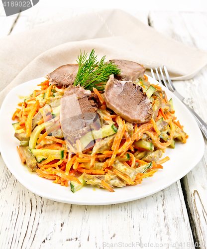Image of Salad of tongue and carrots with napkin on light board