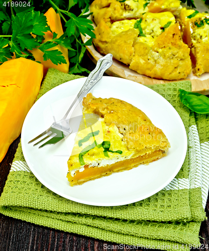 Image of Pie of pumpkin and cheese in plate on dark board