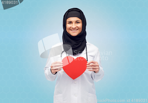 Image of muslim female doctor in hijab holding red heart