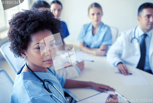 Image of female doctor over group of medics at hospital