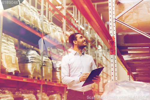 Image of businessman with clipboard at warehouse