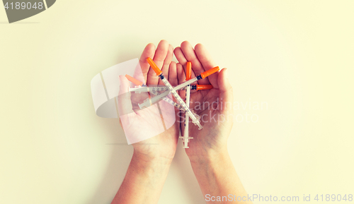 Image of close up of woman hands holding syringes