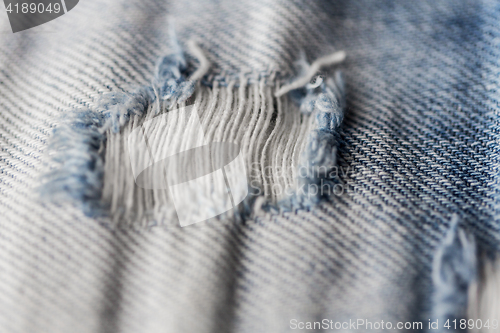 Image of close up of hole on shabby denim or jeans clothes
