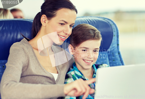 Image of happy family with tablet pc sitting in travel bus