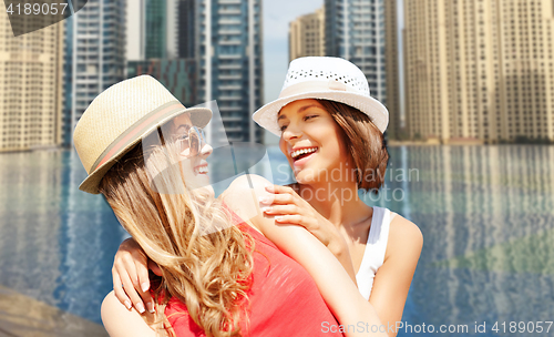 Image of happy young women in hats on summer beach