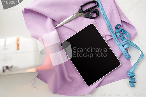 Image of sewing machine, tablet pc, scissors and ruler