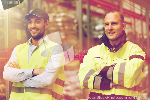 Image of smiling men in reflective uniform at warehouse