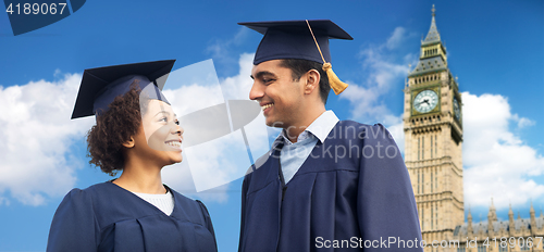 Image of happy students or bachelors in mortar boards