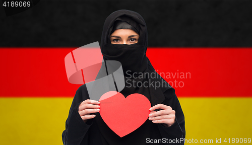 Image of muslim woman in hijab holding red heart