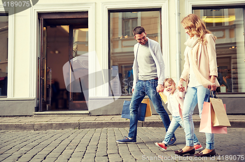 Image of happy family with child and shopping bags in city