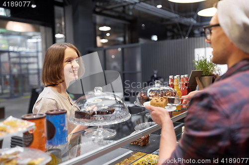 Image of man or barman with cake serving customer at cafe