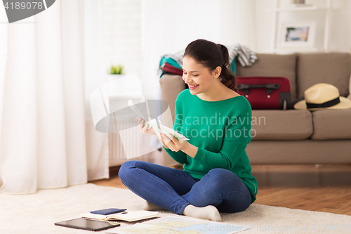 Image of happy woman with money and travel map at home