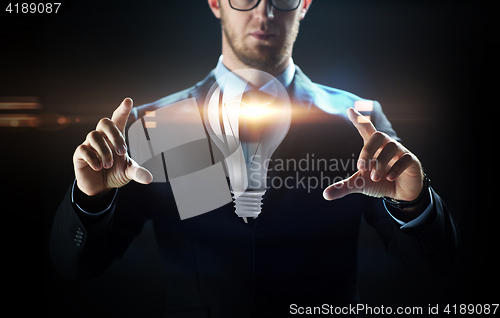 Image of close up of businessman with lightbulb projection