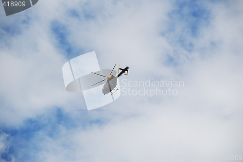 Image of Police Helicopter in a Cloudy Blue Sky