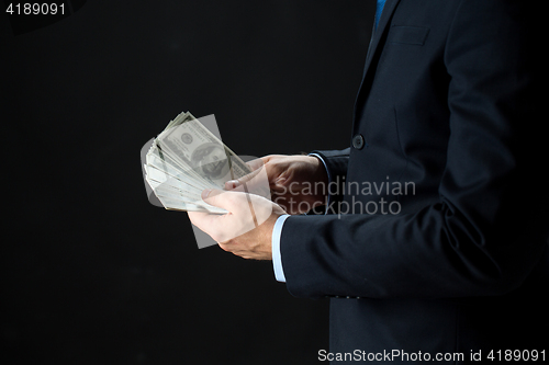 Image of close up of businessman hands holding money