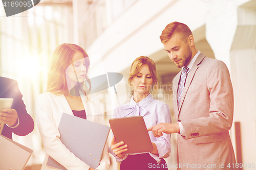 Image of business team with tablet pc and folders at office