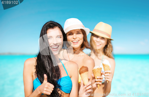 Image of group of happy young women with ice cream on beach