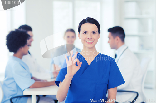 Image of happy doctor over group of medics at hospital