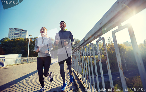 Image of happy couple running outdoors