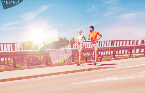 Image of smiling couple running at summer seaside