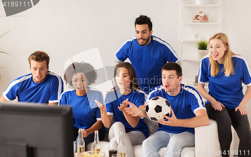 Image of friends or football fans watching soccer at home