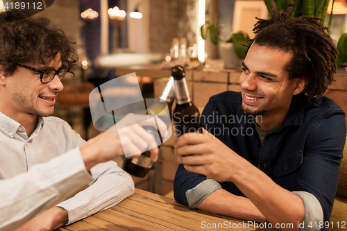 Image of happy male friends drinking beer at bar or pub