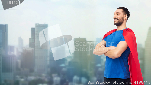 Image of happy man in red superhero cape over city