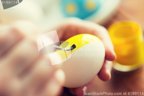 Image of close up of woman hands coloring easter eggs