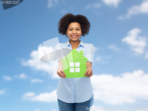 Image of happy african american woman with green house icon