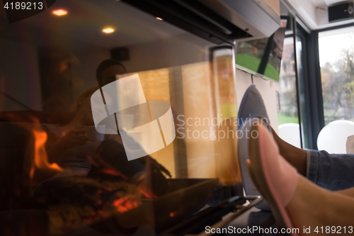 Image of Young multiethnic couple  in front of fireplace