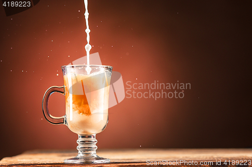 Image of Adding milk to a cup of coffee.