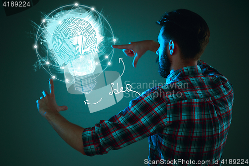 Image of Handsome young man with idea bulb on blue