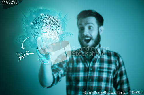 Image of Handsome young man with idea bulb on blue