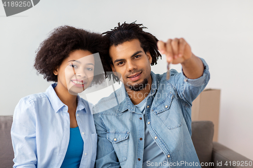 Image of happy couple with key and boxes moving to new home