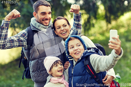 Image of family taking selfie with smartphone in woods