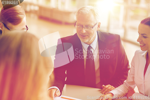 Image of smiling business people meeting in office