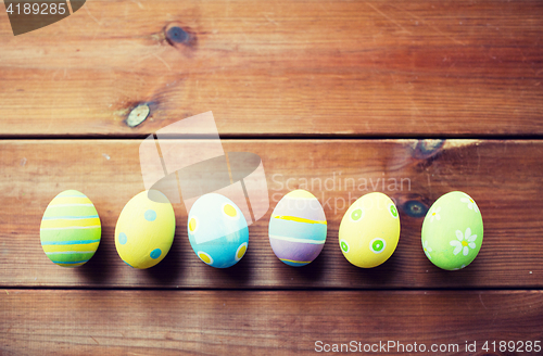 Image of close up of colored easter eggs on wooden surface