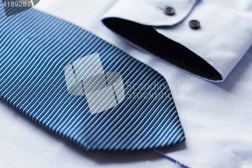 Image of close up of shirt and blue patterned tie