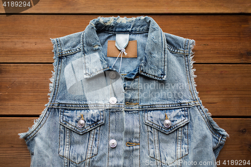 Image of denim vest or waistcoat on wooden background