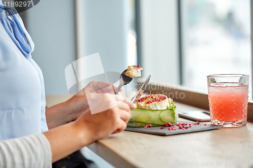 Image of woman eating goat cheese salad at restaurant